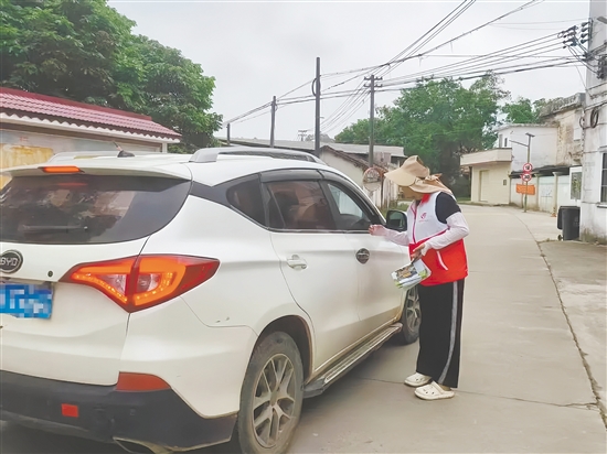 志愿者向过往车辆和上山祭扫的群众发放文明祭扫倡议书。